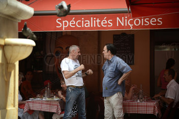 Nizza  Frankreich  zwei Maenner unterhalten sich vor einem Restaurant in der Altstadt Nizzas