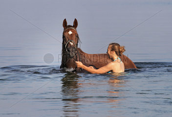 Schwerin  Deutschland  junge Frau badet mit ihrem Pferd im Schweriner See