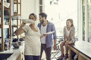 Girl watching as parents prepare family meal