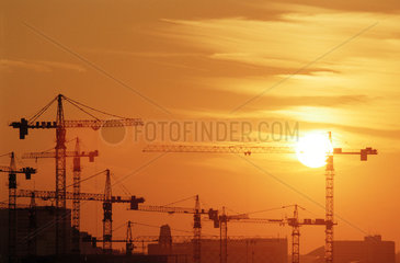 Silhouetten von Baukraenen vor Sonnenuntergang