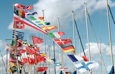 Bunte Laenderflaggen an einem Boot wehen im Wind
