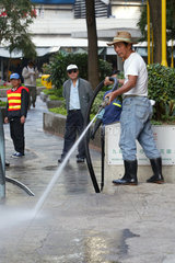 Ein Mann beim Reinigen der Strassen in Kowloon