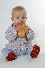 Ein kleines Kind beim Essen eines Broetchen