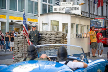 Berlin  Deutschland  ein Cabriolet passiert den ehemaligen Grenzuebergang Checkpoint Charlie
