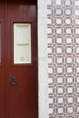 Red door and ornate tiled wall
