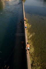 Zuerich  Schweiz  Menschen auf der Mauer des Flussbades Unterer Letten