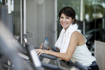Woman hydrating after a workout  smiling