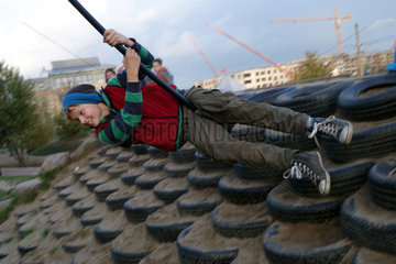Rostock  Deutschland  Junge schaukelt auf einem Spielplatz