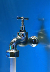 Ein Wasserhahn an einer blau beleuchteten Wand