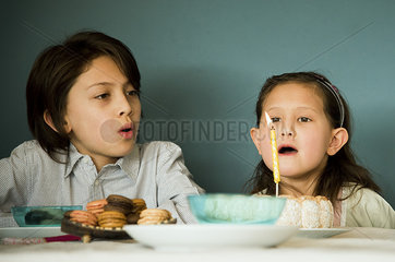 Girl blowing out candle on birthday cake