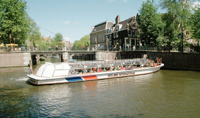Touristenboot bei einer Fahrt durch die Grachten Amsterdams  Niederlande