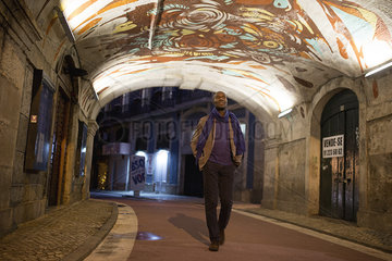 Traveler strolling through graffitied walkway