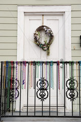 Festive wreath and mardi gras beads on entrance to home
