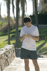 Jogger checking smartphone in park