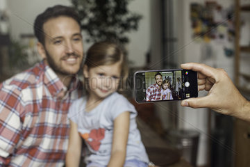 Photographing father and daughter with smartphone