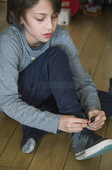 Boy tying his shoe