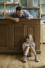 Father looking on as daughter plays video game