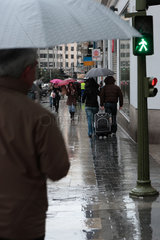Madrid  Spanien  Passsanten mit Regenschirmen auf der Gran Via bei Regen