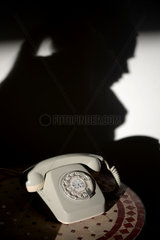 Berlin  Deutschland  alter Telefonapparat und Silhouette einer Frau an der Wand