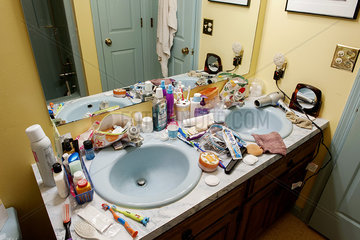 Bathroom sinks cluttered with health and beauty products