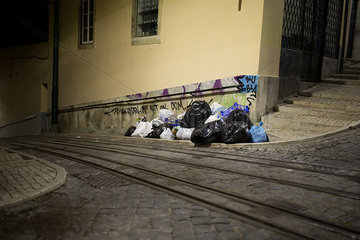 Garbage on side of cobblestone street