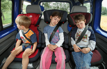 Werl  Deutschland  Kinder sitzen angeschnallt in ihren Kindersitzen im Auto