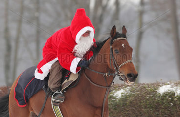 Hoppegarten  Deutschland  Weihnachtsmann reitet auf einem Pferd