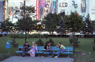 Junge Frauen sitzen im Park am Platz der Einheit (Piata Unirii) in Bukarest