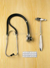 Stethoskop  Reflexhammer und Medikamente auf einem Tisch