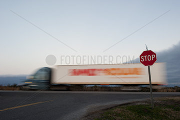 Semi truck moving on road near stop sign