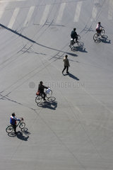 Peking  Fahrradfahrer ueberqueren eine Kreuzung