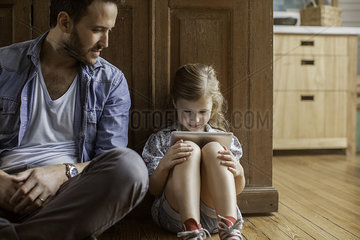 Father watching as daughter plays video game