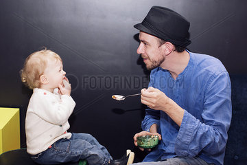 Father feeding toddler