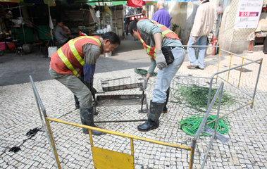 Macau  China  Bauarbeiter wollen Kabel unter der Strasse verlegen