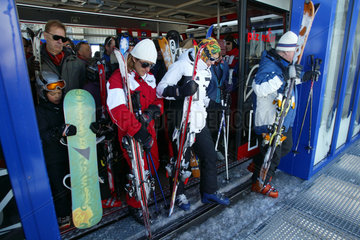 Skifahrer verlassen eine Seilbahn