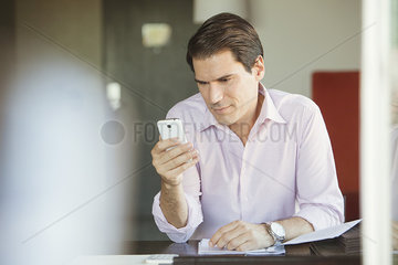 Man checking smartphone in office