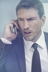 Businessman receiving bad news by cell phone