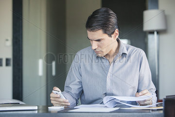 Businessman checking smartphone in office