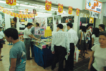 Kunden an den Verkaufstischen mit Musik CD und Videokassetten in Singapur