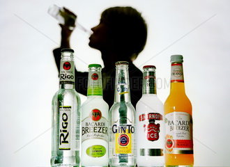 Umriss eines trinkenden jungen Mannes mit Alcopopflaschen