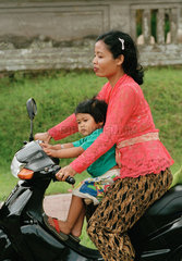 Mutter mit Kind faehrt auf einem kleinen Motorrad