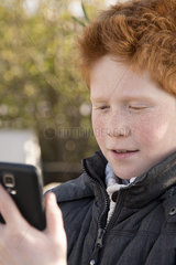 Boy using smartphone outdoors