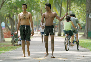 Zwei junge Maenner laufen durch den East Coast Park in Singapur