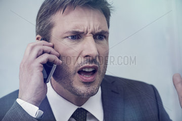 Businessman arguing on cell phone