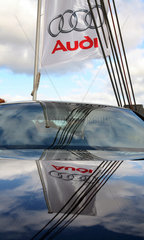 Hannover  Logo des Automobilherstellers Audi auf einer Fahne spiegelt sich auf einer Motorhaube