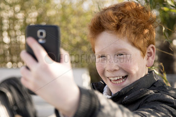 Boy using smartphone to take a selfie