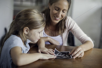 Mother showing daughter ultrasound photo