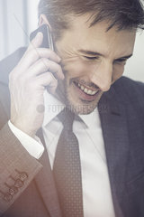 Businessman talking on cell phone  smiling