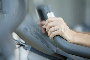 Woman's hands gripping handle of exercise machine  close-up