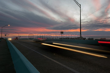 Light trails from traffic on highway at sunset